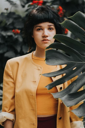 Woman Standing Behind Plant