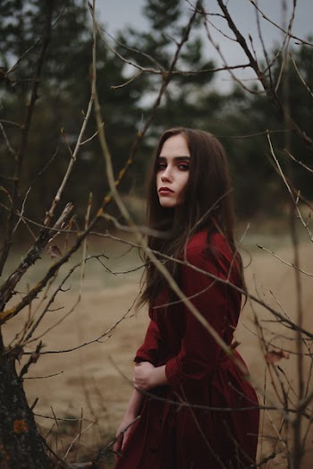Woman Standing Behind Tree Branches