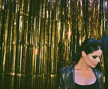 Woman Standing Beside a Gold Foil Curtain