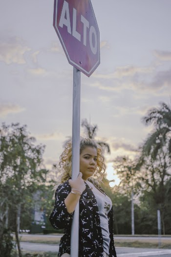 Woman Standing Beside Alto Signage