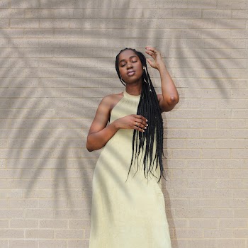 Woman Standing Beside Beige Wall