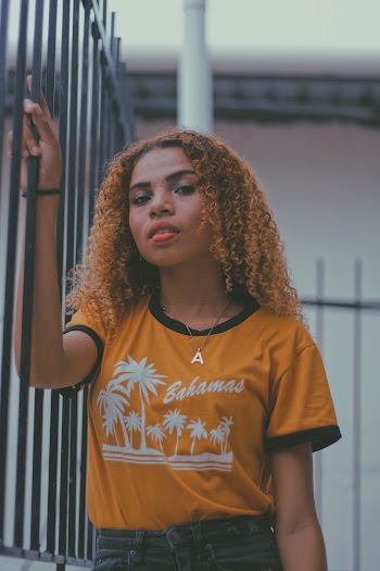 Woman Standing Beside Black Fence