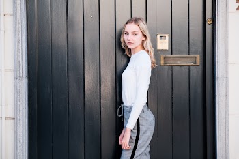 Woman Standing Beside Black Wooden Door