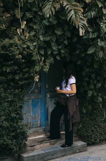 Woman Standing Beside Blue Wooden Door