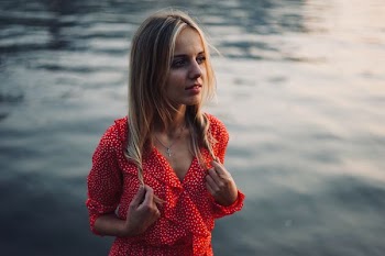 woman standing beside body of water