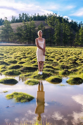 Woman Standing Beside Body of Water Near Mountain