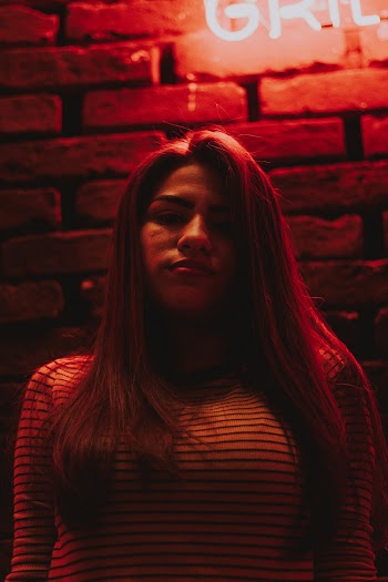 Woman Standing Beside Brick Walle