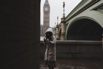 woman standing beside brown wall
