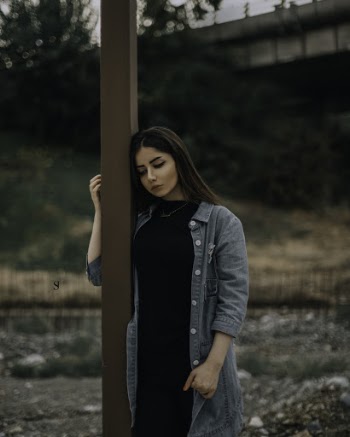 Woman Standing Beside Brown Wooden Post