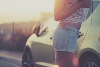 woman standing beside car