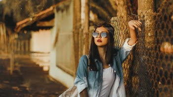 Woman Standing Beside Chain-Link Fence