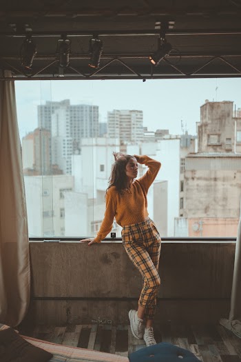 Woman Standing Beside Clear Glass Window