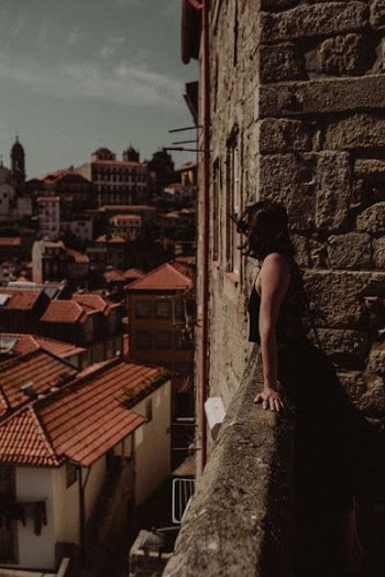 woman standing beside concrete handrails