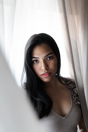 Woman Standing Beside Curtain