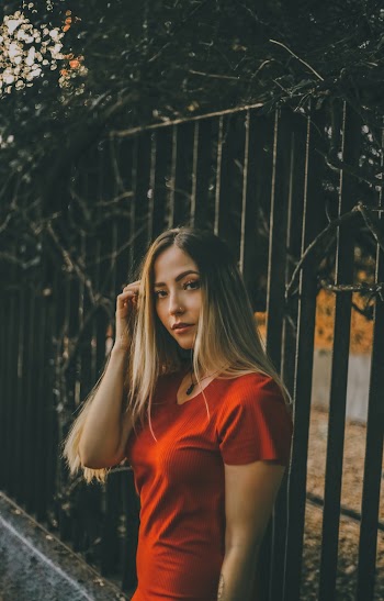 Woman Standing Beside Fence