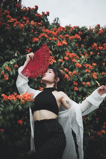 Woman Standing Beside Flowering Plant