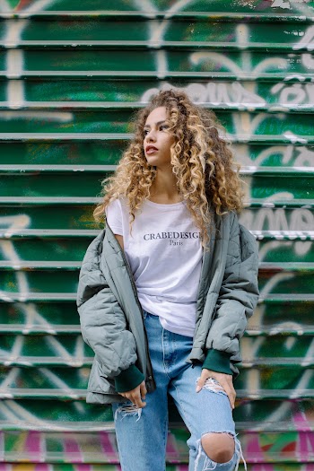 Woman Standing Beside Green and White Graffiti