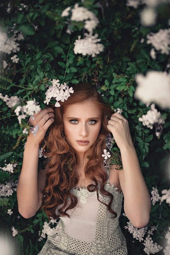 Woman Standing Beside Green Bush With White Flowers