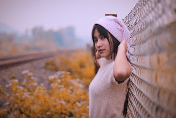 Woman Standing Beside Grey Fence