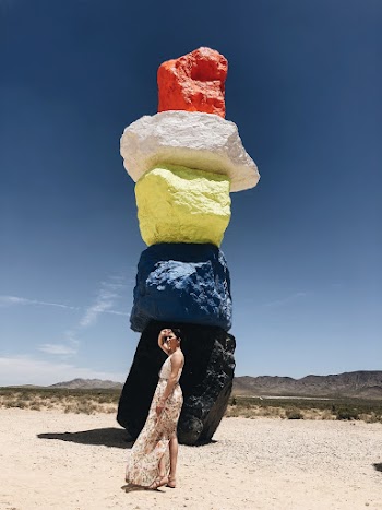 Woman Standing Beside Multicolored Rock Formation
