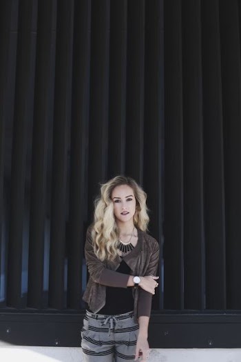 woman standing beside pleated curtain