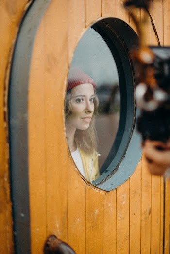 Woman Standing Beside Round Glass Window