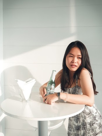Woman Standing Beside Table Holding Heineken Beer Bottle