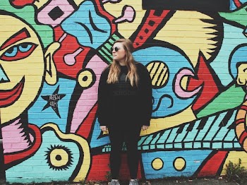 woman standing beside wall with graffiti