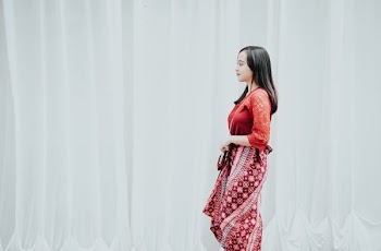 woman standing beside white curtain
