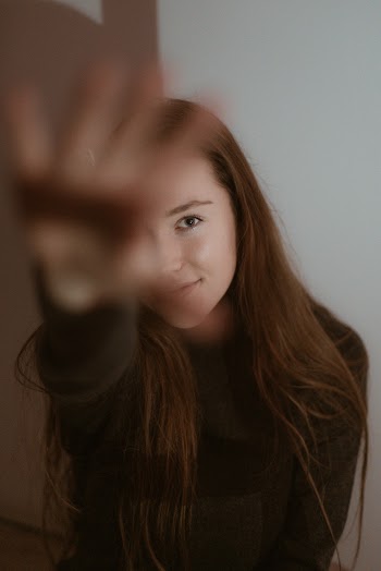 Woman Standing Beside White Painted Wall