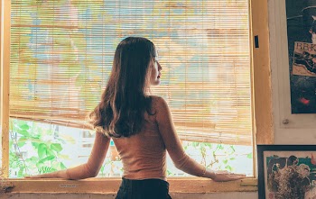 Woman Standing Beside Window