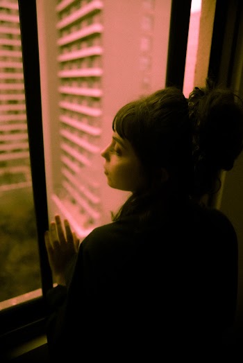 Woman Standing Beside Window Looking Out