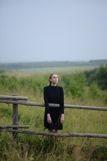 Woman Standing Beside Wooden Fence on Ranch