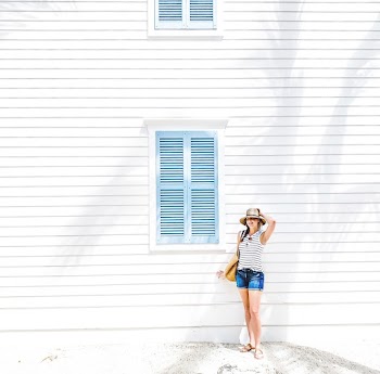 Woman Standing Beside Wooden House