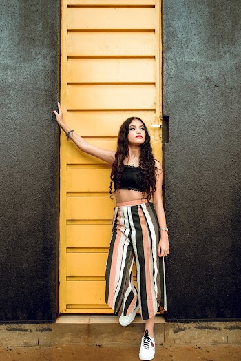 Woman Standing Beside Yellow Metal Door
