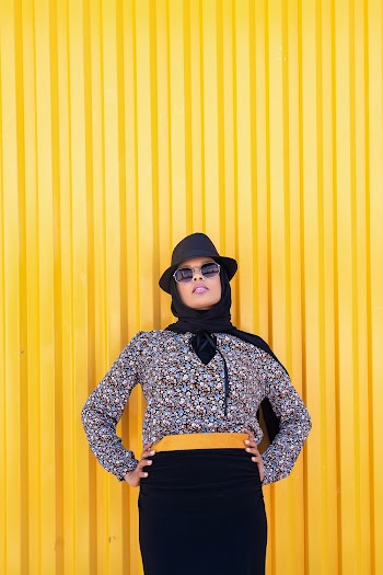 Woman Standing Beside Yellow Wall