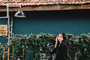 Woman Standing Besides Green Leaves