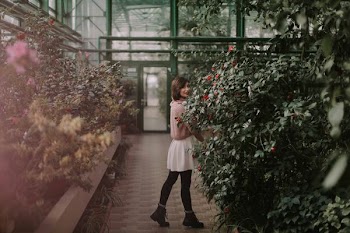 woman standing between garden of flowers