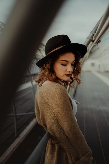 woman standing between white metal fences