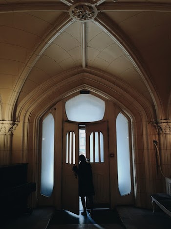 Woman Standing by an Open Door