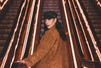 Woman Standing by Escalator Looking Backwards