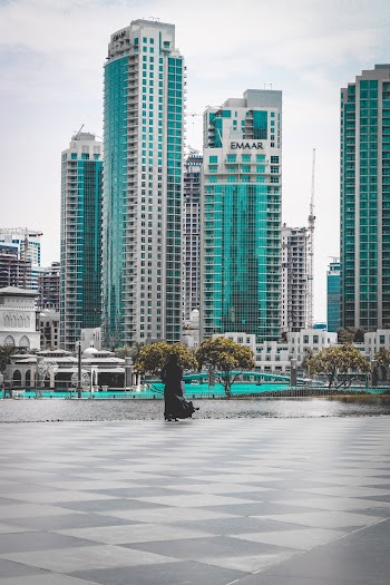 Woman Standing Facing High Rise Buildings
