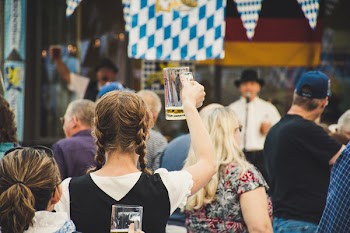 Woman Standing in a Crowd Holding Up Beer Glass