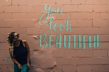 Woman Standing in Beige Concrete Block With You Look Beautiful Paint