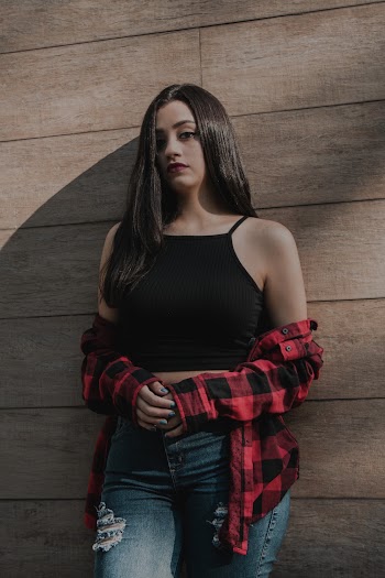 Woman standing in Black Crop Top Leaning on Wall