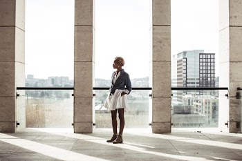 woman standing in building next to window