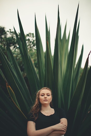 Woman Standing In Front Of A Plant