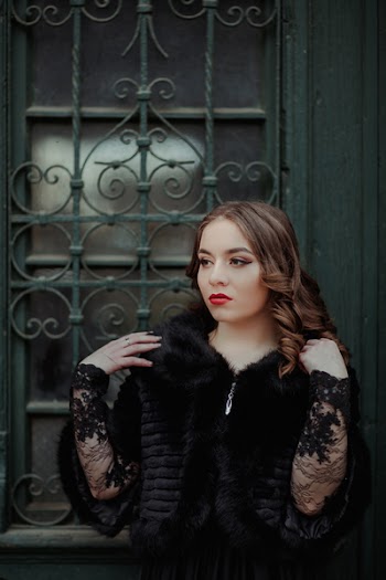 Woman Standing in Front of Black Metal Gate