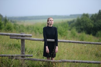 Woman Standing in Front of Brown Wooden Fence