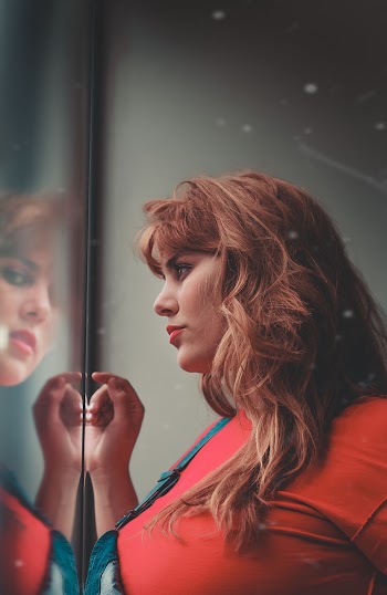 Woman Standing in Front of Glass Wall